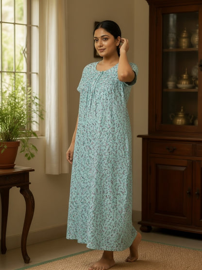 Kishona light blue cotton nightgown with dainty floral print, round neckline, and pleat details on a woman.