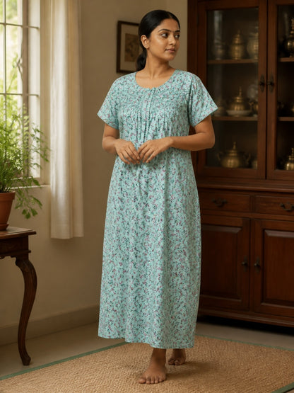 Kishona light blue cotton nightgown with dainty floral print, round neckline, and pleat details on a woman.